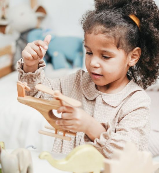 Preschool girl focused and content on playing with her toy helicopter